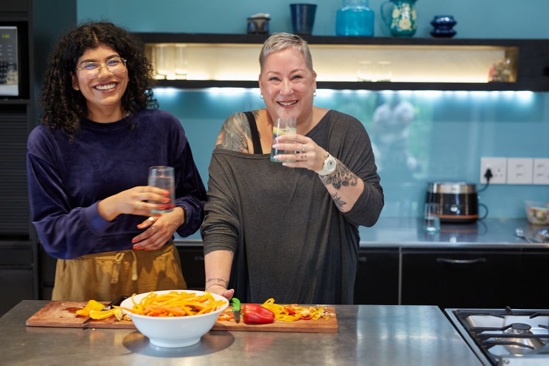 Two South African friends sharing a laugh while preparing vegetables.